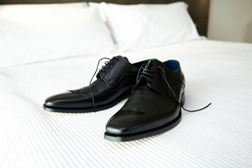 Black man shoes on a white bed