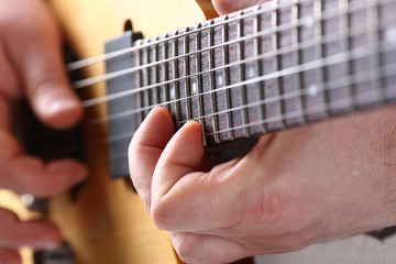 Male arms playing classic shape electric guitar