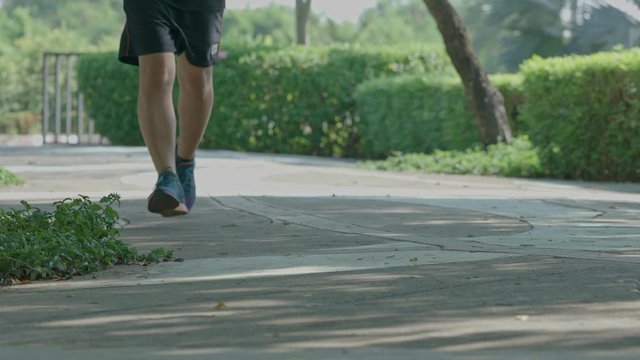 Footage of sportman running intense cardio workout exercise in park at urban city.