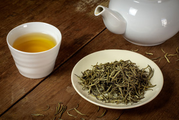 Best quality of green tea specially selected early in the morning served on wooden table with white teapot. It is called white tea for the quality.