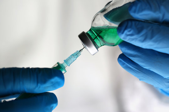 Scientist Holding Green Drug Vaccine Syringe