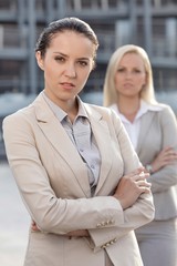 Portrait of confident young businesswoman with female colleague in background