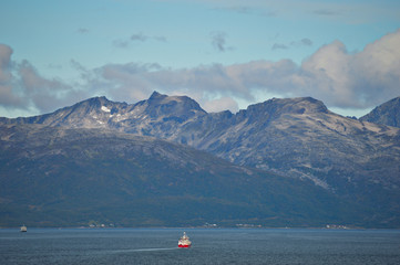 Cargo ship with mountains background near the city of Tromso
