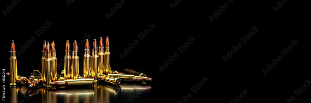 Poster Bullet isolated on black background with reflexion. Rifle bullets close-up on black back. Cartridges for rifle and carbine on a black.