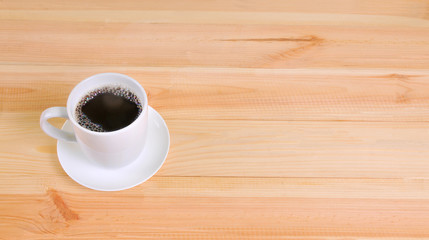 Coffee cup on wooden table background, copy space