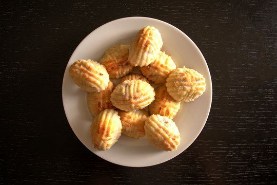 Traditional eastern mamoul cookies. Top view. Arabic baked sweets on white plate on dark wooden table. Ayd El Fithr feast cookies.