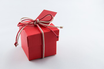 Piccola scatola rossa con fiocco di corda colorata e bigliettino rosso