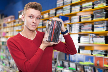 Young man choosing movies on DVD at store
