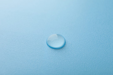 Water drop on blue background, macro and space for text