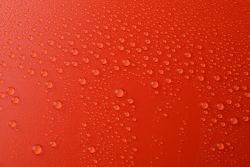 Many water drops on red background. Texture background.