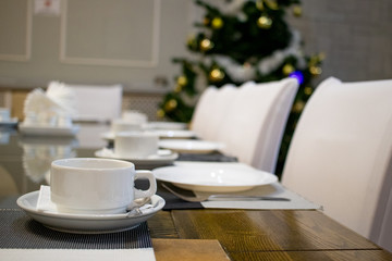 a served table in a restaurant with cups and appliances for Christmas evening