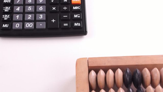 Vintage wooden abacus and modern calculator. Camera move over objects. Close-up