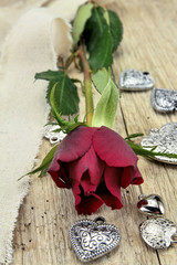 red rose and heart on a wooden table