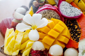 Juicy ripe tropical Thai fruits on a wooden dish.