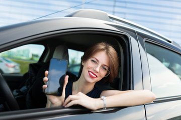 Beautiful woman in strict style of clothing, red lips, short haircut gets out of the car for an important meeting in the office, goes for an interview
