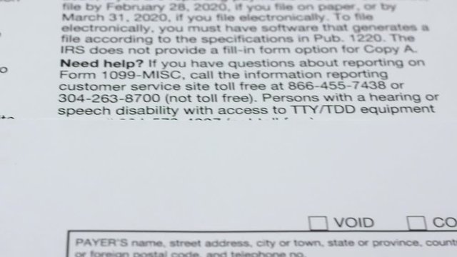 Tax reporting. The instruction for the payer lies next to 1099-misc tax form and pen. Macro video