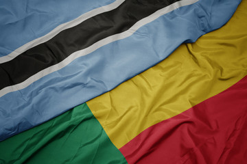waving colorful flag of benin and national flag of botswana.