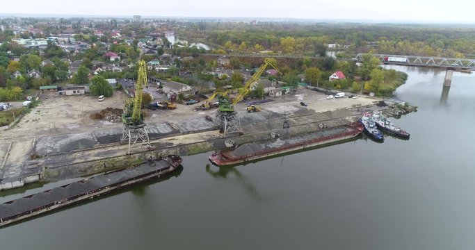 Large cranes in the port unload the barge with the material, port cranes work from the top
