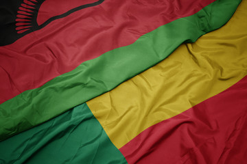 waving colorful flag of benin and national flag of malawi.