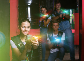 Young girl with laser gun took aim, having fun with friends duri