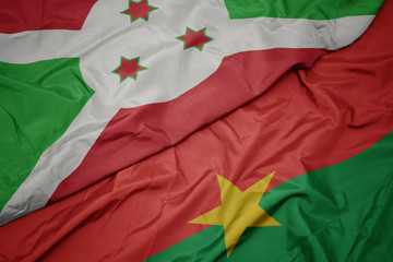 waving colorful flag of burkina faso and national flag of burundi .