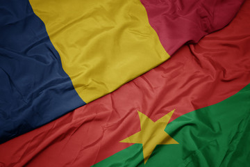 waving colorful flag of burkina faso and national flag of chad.