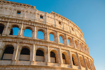 Fototapeta premium Colosseum or Coliseum ancient ruins background blue sky Rome, Italy