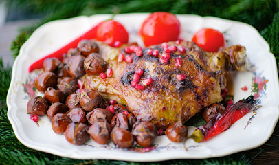 The idea for the New Year's table, baked lamb with rosemary, garlic, and hot pepper. Garnished with baked chestnutThe idea for the New Year's table, baked lamb wis and salted tomatos and pomegranates.
