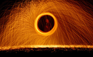 Burning steel wool fireworks spinning in dark night