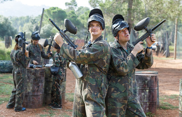 Fototapeta premium Two men in camouflage with guns ready for playing paintball with friends