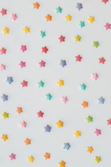 Many colorful stars of cake sprinkels on a white background.