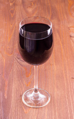 wineglass of red wine on a wooden table in a restaurant. Drink close up. concept problem of alcohol addiction, alcoholism dependence