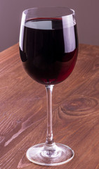 wineglass of red wine on a wooden table in a restaurant. Drink close up. concept problem of alcohol addiction, alcoholism dependence
