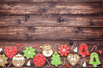 Fototapeta na wymiar Christmas gingerbread cookies with candies and ornaments on brown wooden table