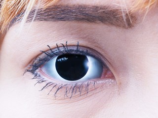 A beautiful eye of a young lady with the total solar eclipse eye, black eyelash and eyebrow, and blond hair