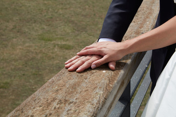 Couple holding hands on a brown handrail