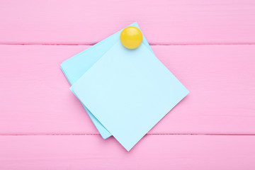 Paper sticky note on pink wooden table