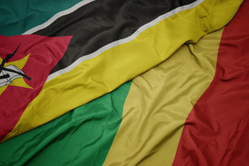 waving colorful flag of republic of the congo and national flag of mozambique.