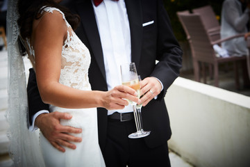 Bride and groom toasting (cheers) with two glasses of champagne