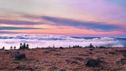 On the mountain top at sunset over a sea of clouds. A sky in beautiful colors, Mount Brocken, Harz mountain range, Saxony-Anhalt, Germany.
