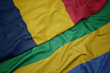 waving colorful flag of gabon and national flag of chad.