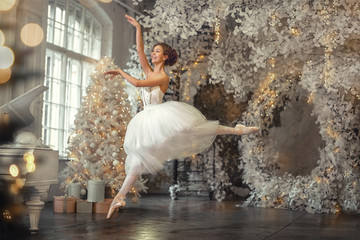  beautiful russian girl dancing in white near a new year tree