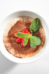 Italian Tiramisu Dessert with Green Fresh Mint and Sliced Strawberries