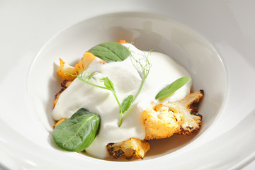 Baked Cauliflower with Cream Sauce and Fresh Greens Isolated