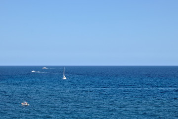 4 boats in the ocean and the horizon in the middle