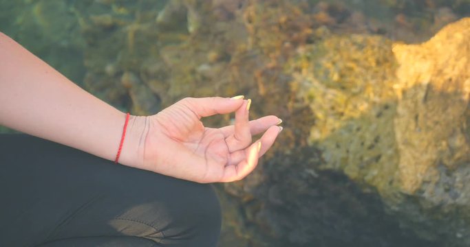 Finger mudras in lotus pose near the sea