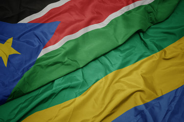 waving colorful flag of gabon and national flag of south sudan.