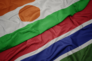 waving colorful flag of gambia and national flag of niger.