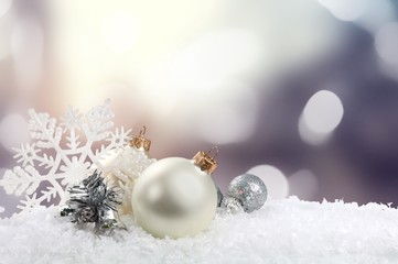 Silver and white christmas balls on white snow