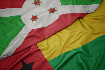 waving colorful flag of guinea bissau and national flag of burundi .
